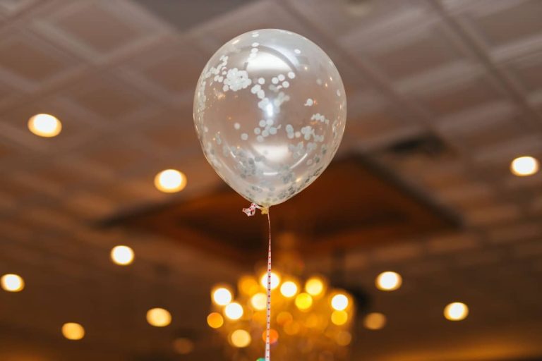 Globo transparente con confeti bajo el techo iluminado de un salón