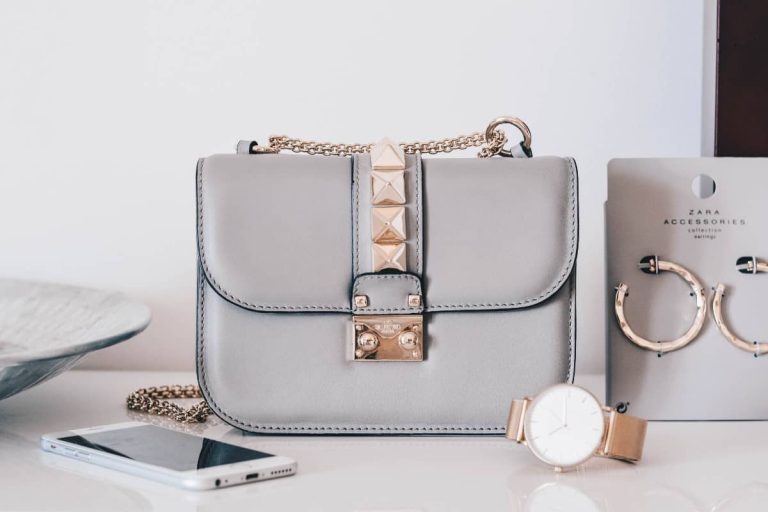 Bolso gris con tachuelas, pendientes y reloj