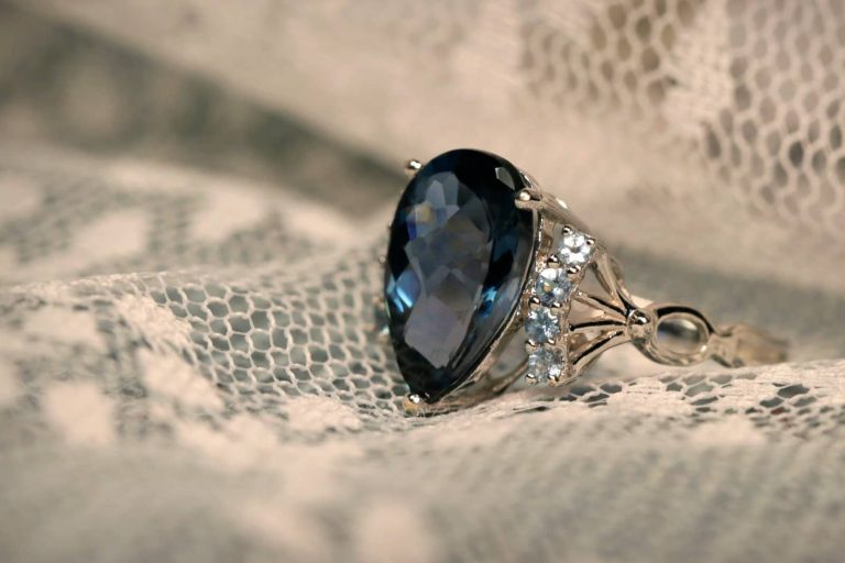 Anillo con una piedra azul sobre encaje