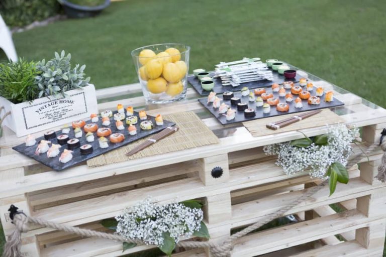 Mesa de palés en el jardín con bandejas de sushi