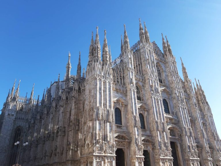 Fachada gótica de una catedral bajo un cielo azul