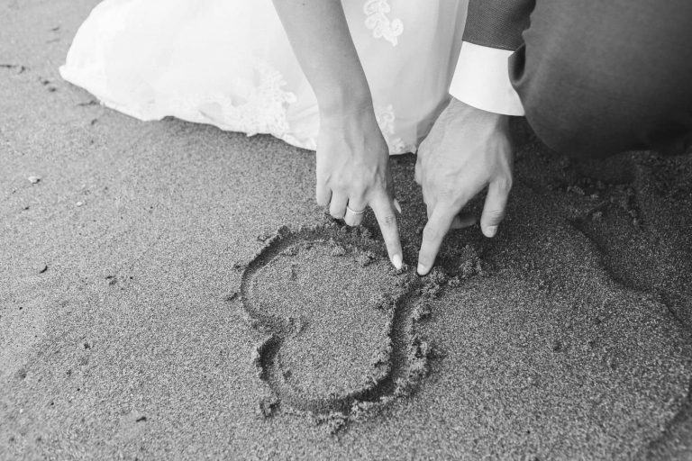 Novios dibujando un corazón en la arena