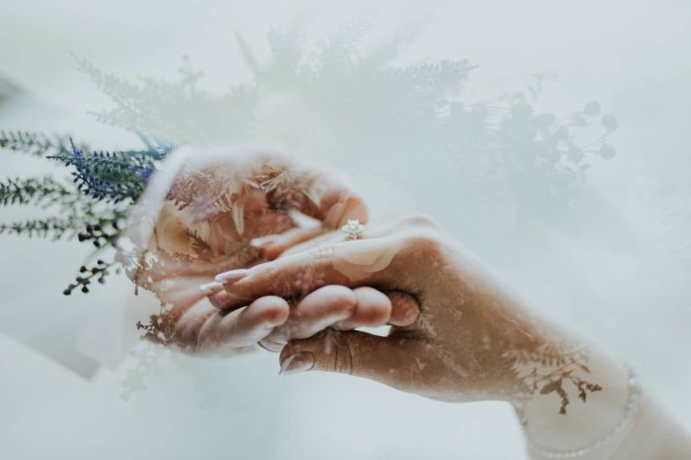 Manos de los novios entrelazadas entre la nieve