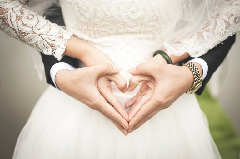 Novios formando un corazón con las manos