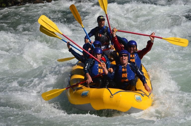 Grupo haciendo rafting en una balsa amarilla